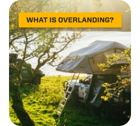 An Overland Bound truck camping by water on a sunny day.